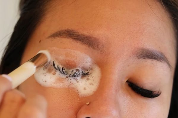 a white girl is using Alluring Foam Cleanser for Eyelash Extensions